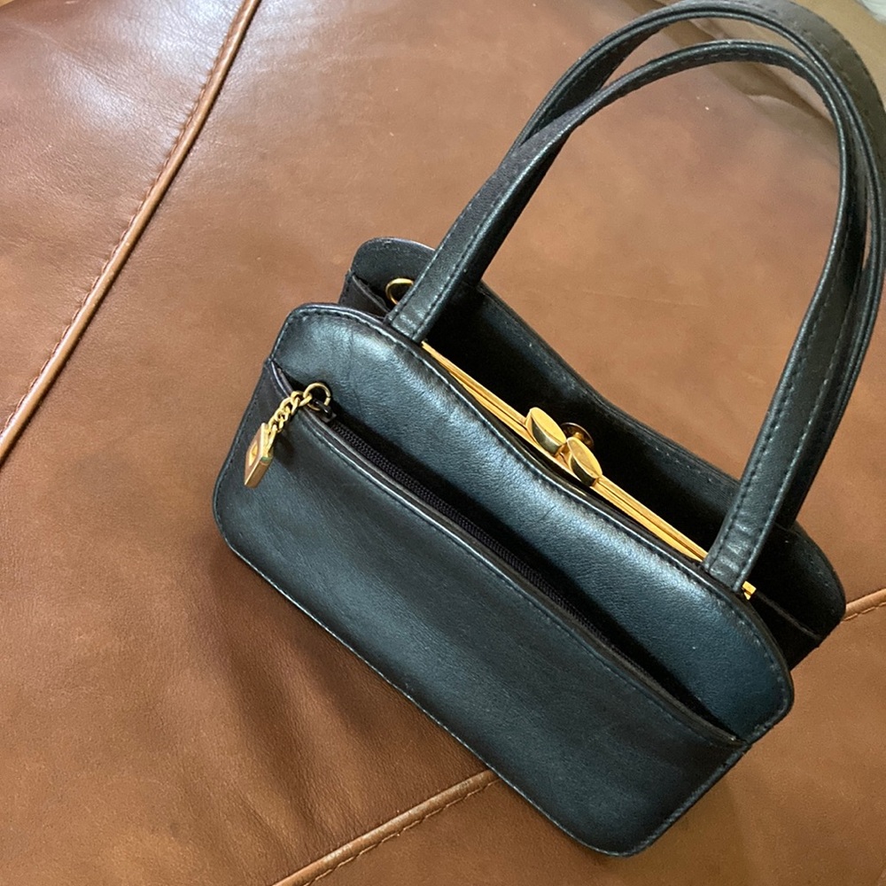 Small hand bag. 8” L x 5 “. Handle straps. No shoulder strap.
